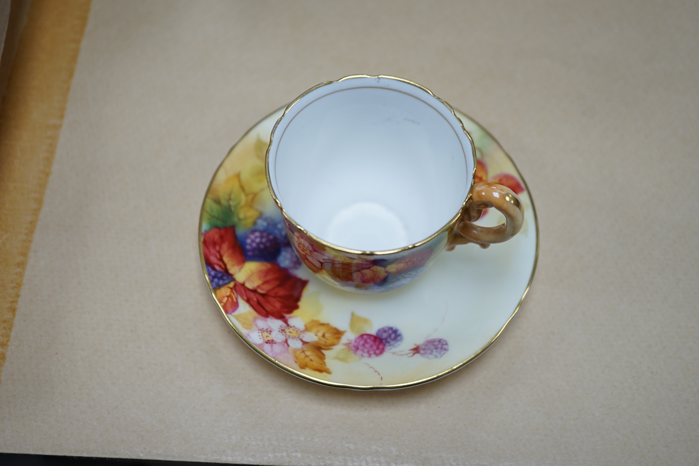 A Royal Worcester fruit painted cup and saucer by Kitty Blake, saucer 11.5cm diameter. Condition - good